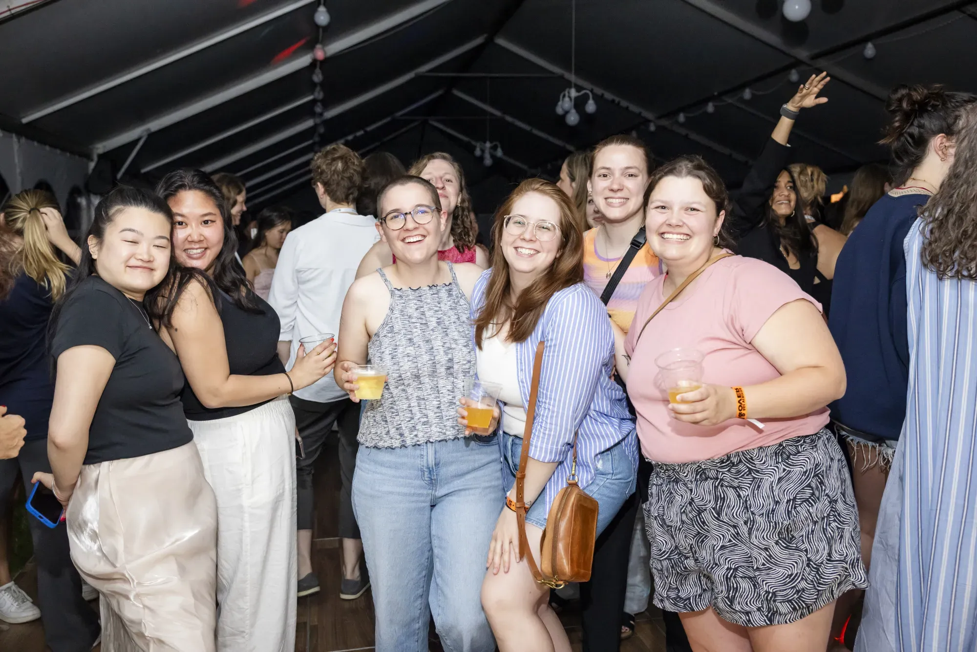 A group of alums smiling at the camera, some holding drinks